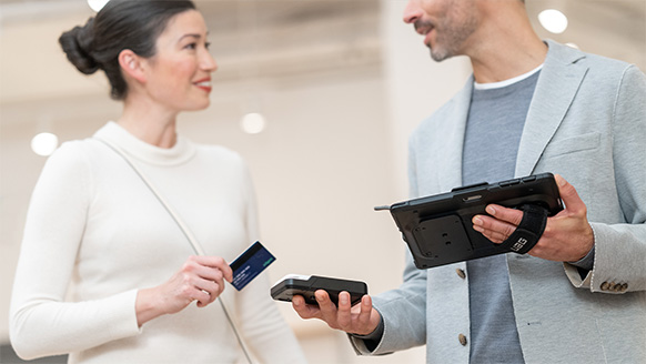 某人使用 Surface Go 4 商用版和各种配件来完成与某客户的信用卡交易。