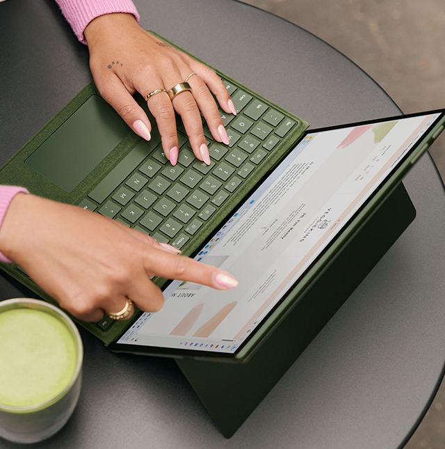 一个人用手指与 Surface 设备的触摸屏进行交互。