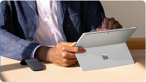 一位用户正在使用翻开内置一体式支架的 Surface Pro 商用版。