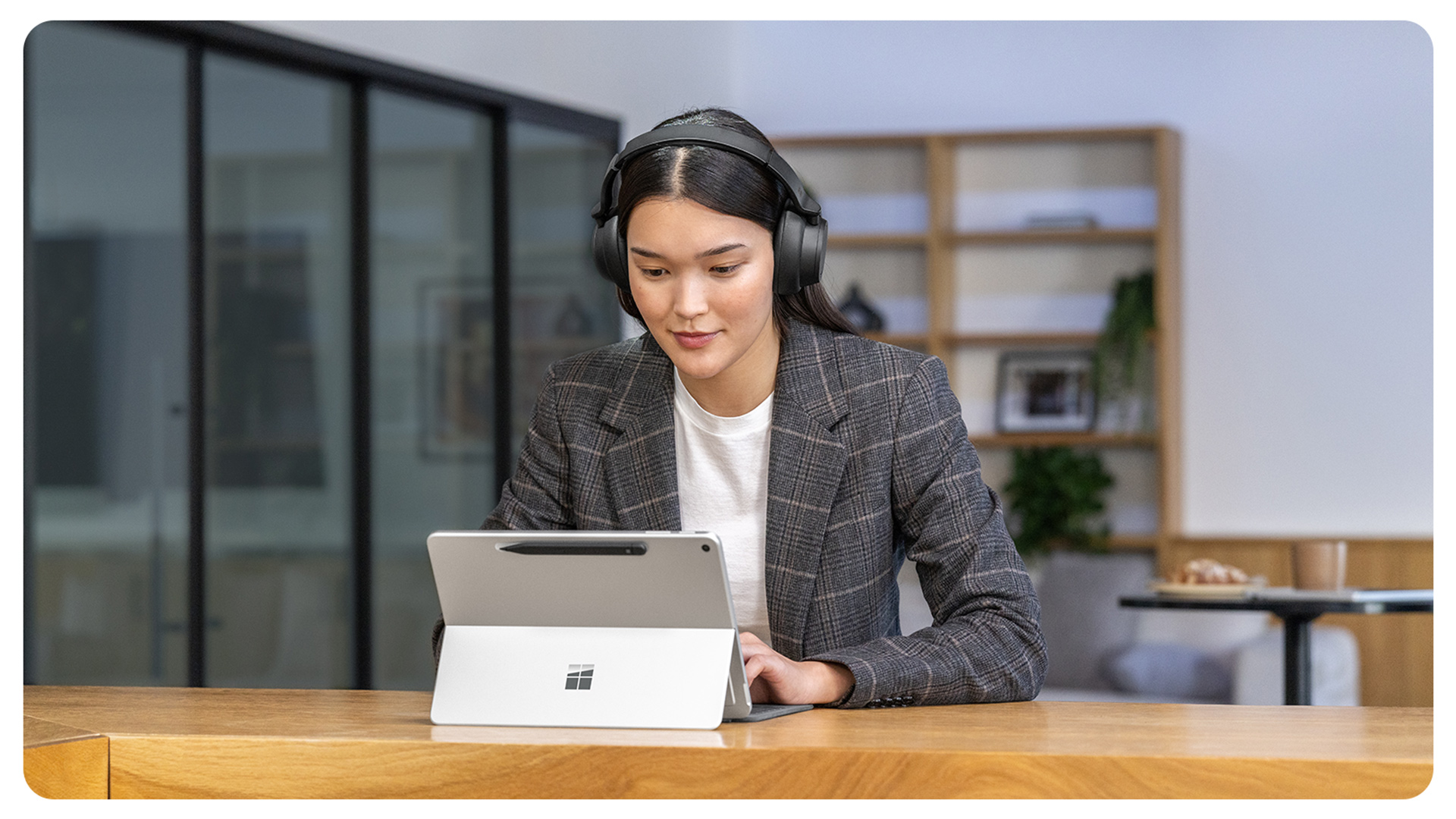 一个人正在使用 Surface Pro 商用版，一体式支架处于展开状态。