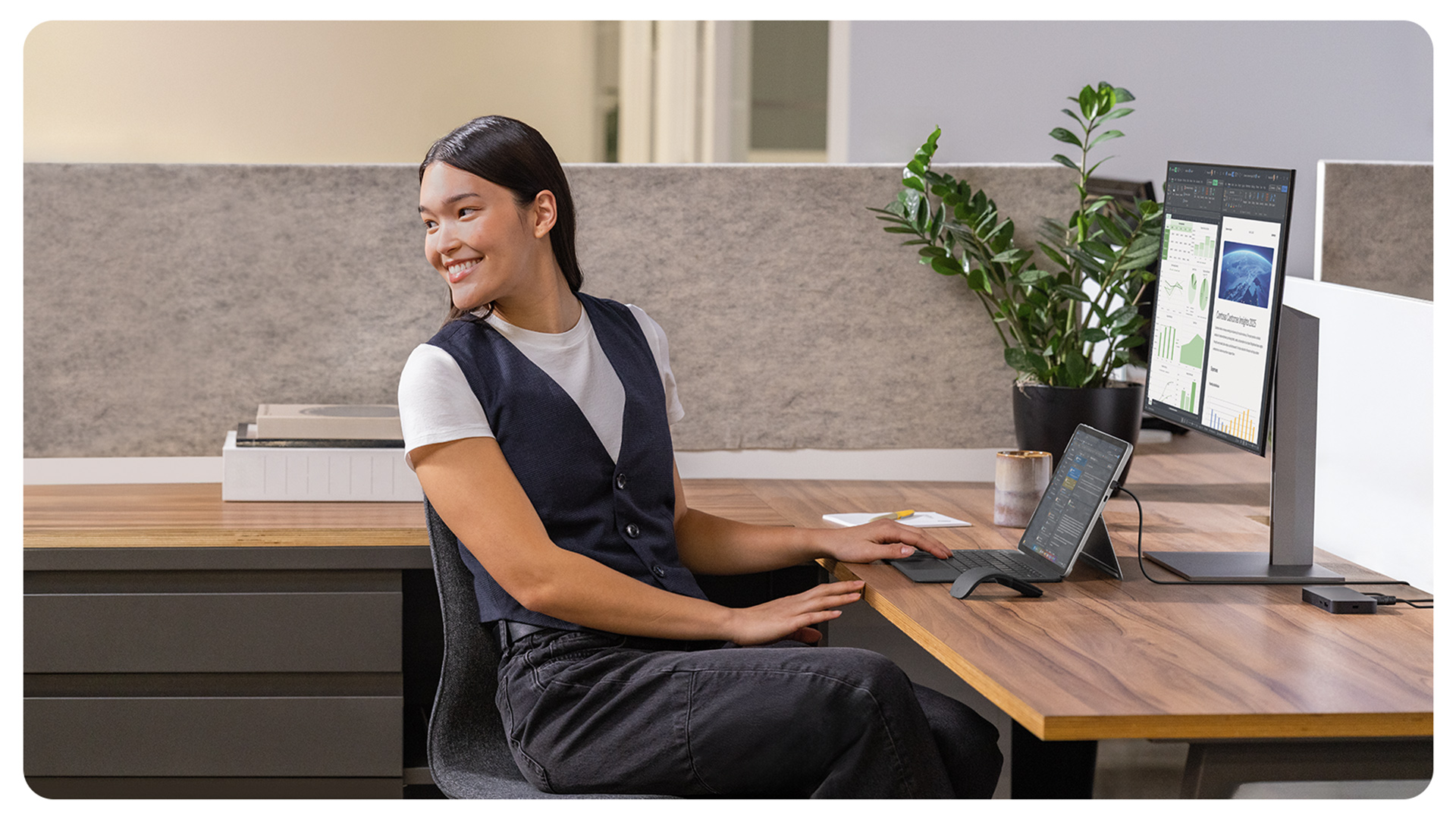 一个人在办公室里微笑着使用 Surface Pro 商用版。