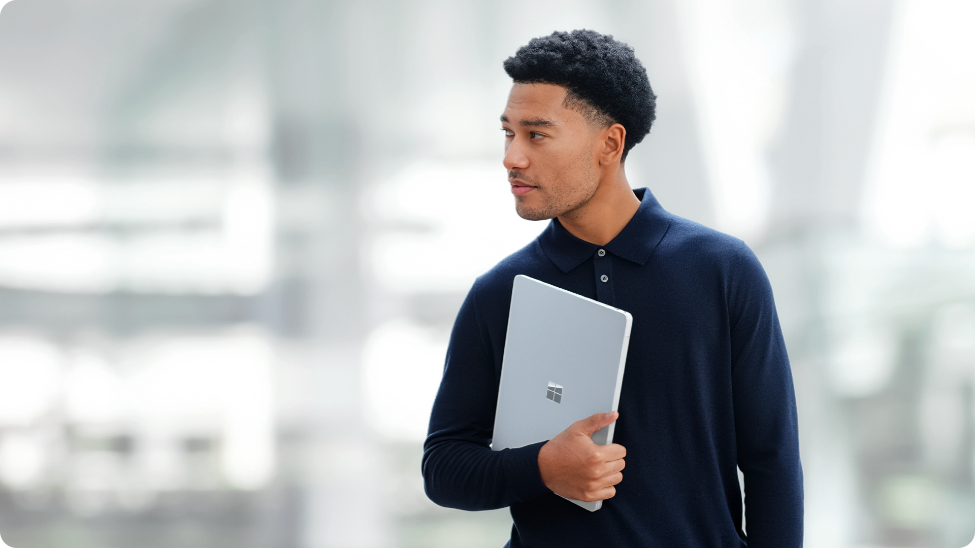 用户手持 Surface Laptop 商用版，展现设备的便携特性。
