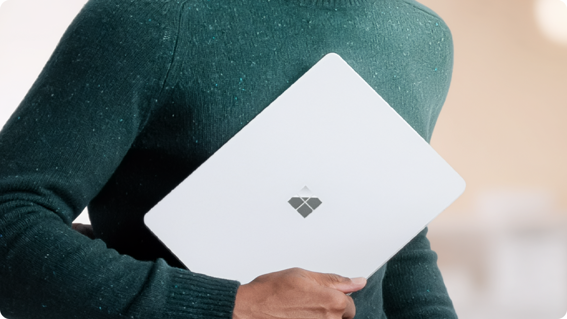 人物手持 Surface Laptop 商用版的特写，展示设备的便携性。