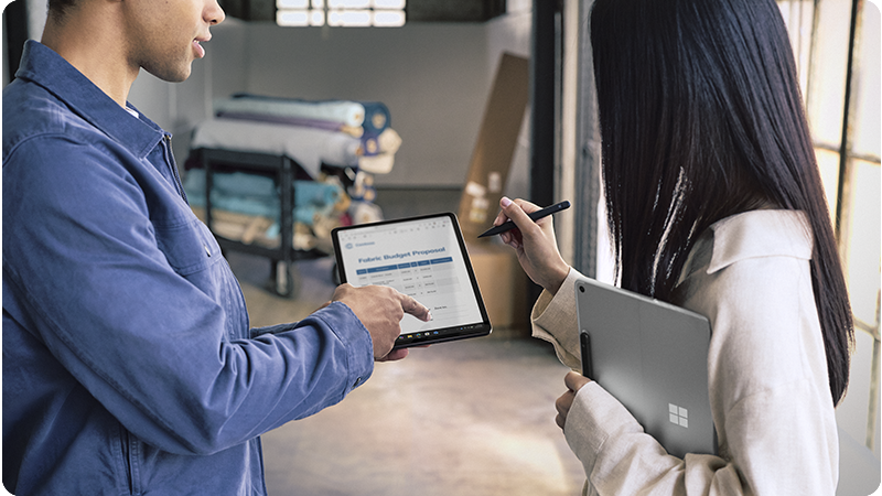 两位手持 Surface Pro 商用版设备、使用超薄触控笔的用户。