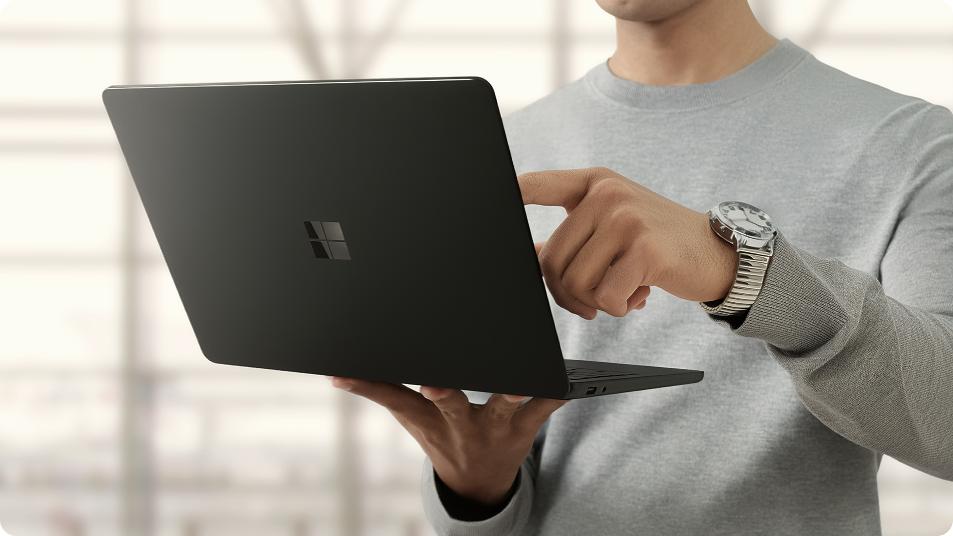 一位使用者手持未连接电源的 Surface Laptop 商用版，展现超长续航。